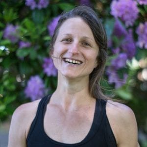 Veronique Rioux, smiling with purple flowers in background